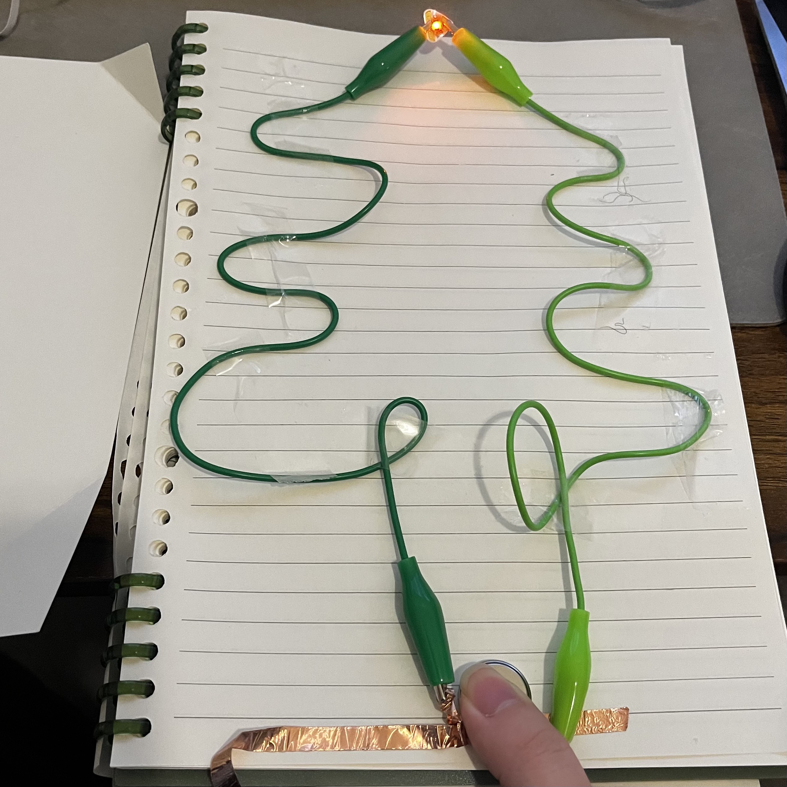 I pressed where the copper tape connects to the battery to make it lighting up