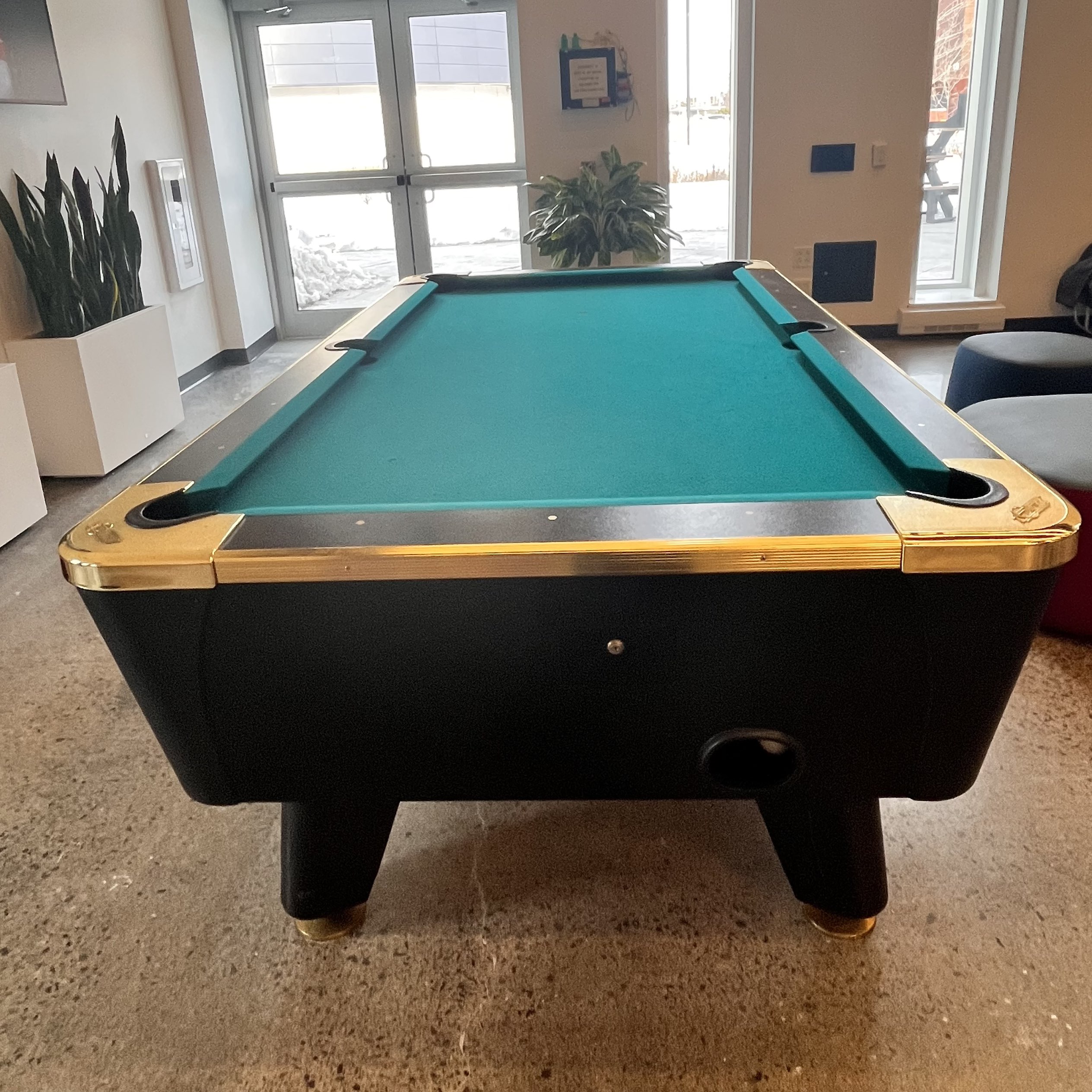 There's people playing billiards in the marquee, I can hear the sound of a billiard ball being struck, dropping into the pocket, then rolling along the return track.