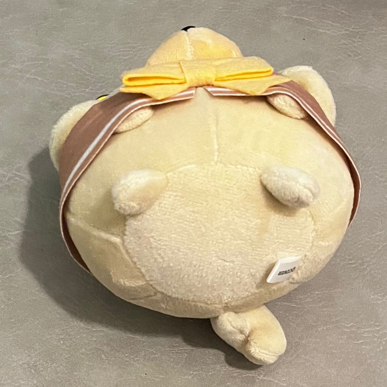 This photo of the dog plush is taken from its below. You can see the tail.